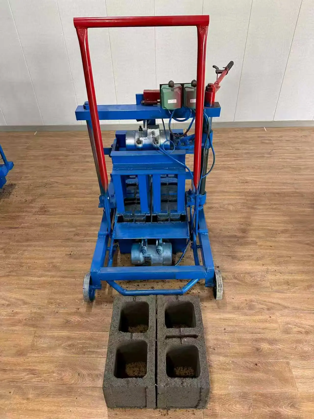 Small mobile block making machine that lays fresh hollow blocks on the ground